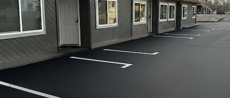 Una hilera de edificios de una planta con un estacionamiento al frente.