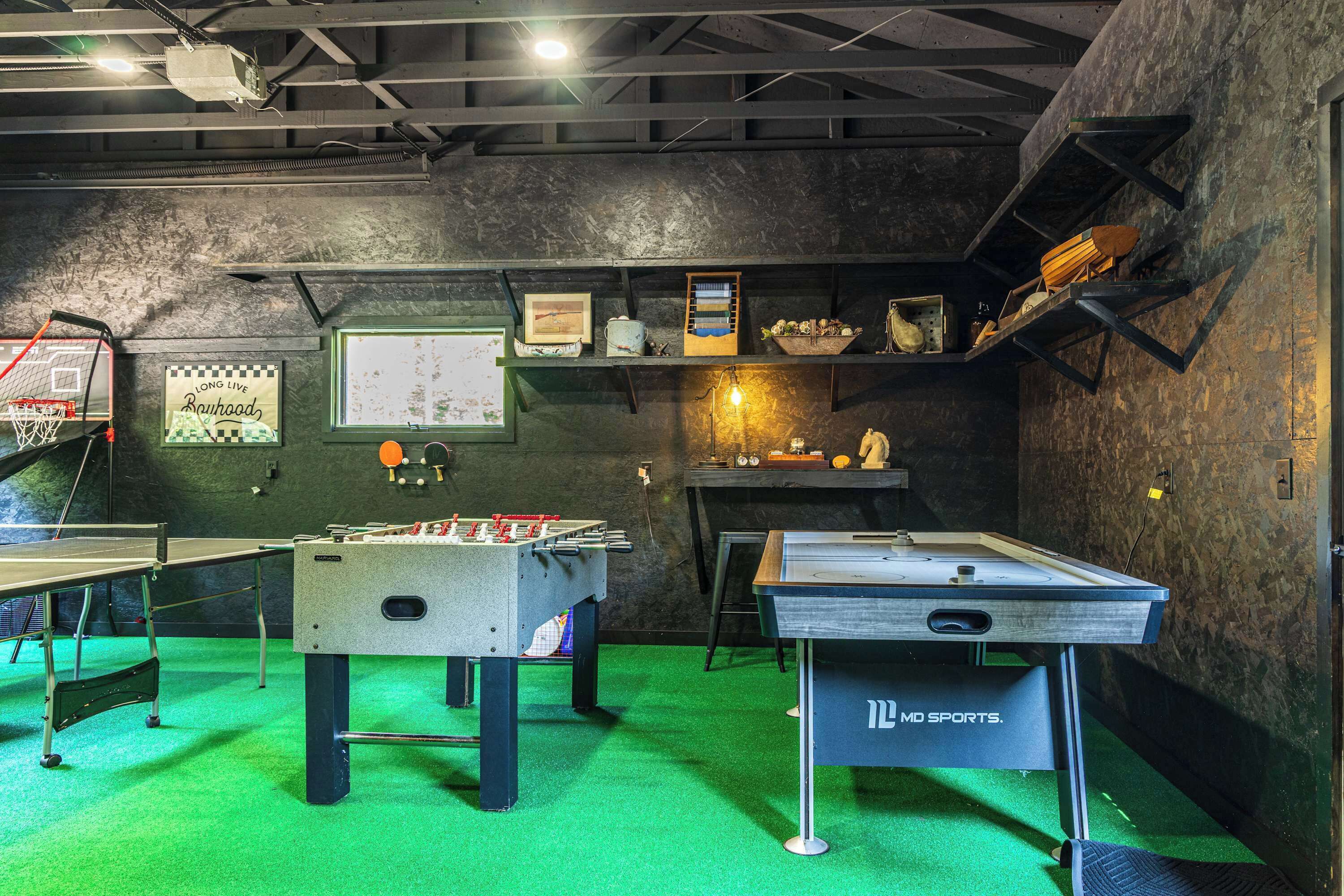 Une salle de loisirs équipée d’un baby-foot, d’une table de ping-pong et d’un autre baby-foot de la marque « MD SPORTS ».