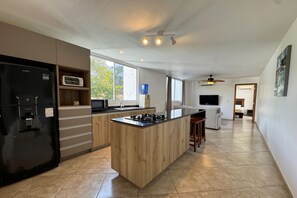 Departamento Deluxe | Cocina privada | Refrigerador, microondas, parrilla de estufa y utensilios de cocina
