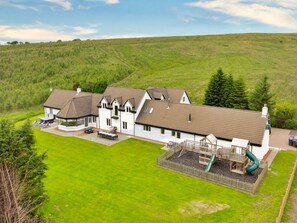 A large, two-story building with a covered patio area and a playground. - Luxury Country Estate Near Largs (Largs)