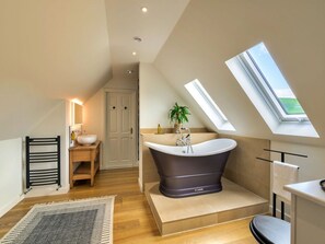 A modern bathroom with a freestanding bathtub, a vanity with a sink, and a skylight. - Luxury Country Estate Near Largs (Largs)