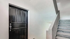 A black door with a handle and a keyhole, leading to a staircase with a handrail and steps. - Modern Oasis 2BR Condo/ Walk to Camarones Beach & Malecón (Puerto Vallarta)