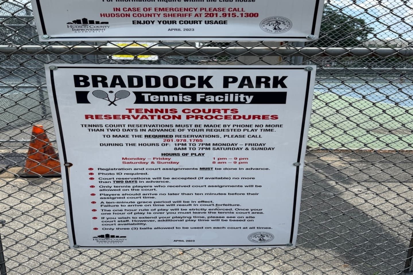 Letrero del Complejo de Tenis Braddock Park que detalla los procedimientos de reserva y horarios de las canchas.
