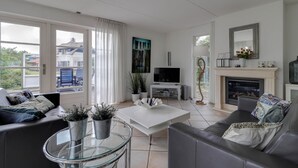 A modern living room with a fireplace, television, and seating area. - Detached Dune Villa With Hot-tub (Makkum)