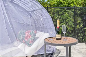 A covered outdoor seating area with a bottle of Moët & Chandon champagne and two glasses on a round table. - Modern Boutique House/Heated Pool/Clearwater/Tampa (Tampa)