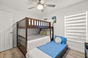 A bunk bed room with a ceiling fan, a window with blinds, and a small picture on the wall. - Modern Boutique House/Heated Pool/Clearwater/Tampa (Tampa)