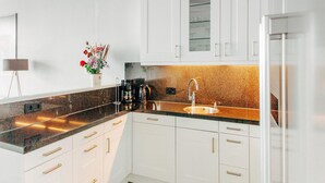 Een moderne keuken met witte kasten, een granieten werkblad en een roestvrijstalen spoelbak.
