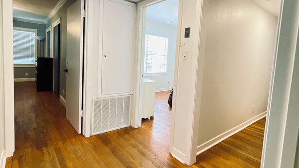 A hallway with wooden flooring, white walls, and a ceiling light. - Spacious 4-bedroom house in gorgeous Houston with AC (Houston)