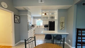 A modern kitchen with white cabinetry, a dining table, and chairs. - Spacious 4-bedroom house in gorgeous Houston with AC (Houston)