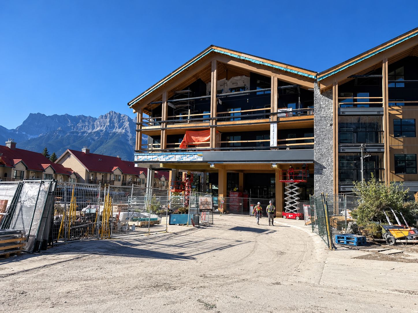 A multi-story building with a wooden facade, a covered entrance, and a view of mountains in the background.