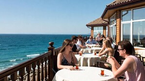 A seaside restaurant with outdoor seating overlooking the ocean. - otel ustabaş (Hopa)