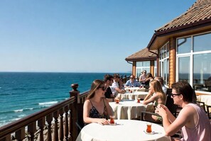 A seaside restaurant with outdoor seating overlooking the ocean. - otel ustabaş (Hopa)