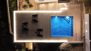 An aerial view of a rooftop swimming pool with a sun terrace, surrounded by a stone wall and vegetation. - Luxury 5-Bedroom Villa Forte Sevid with Pool, Jacuzzi & Sea View (Sevid na moru)