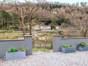 A view of a river with a bridge, surrounded by trees and houses in the background. - Contemporary Cornwall Retreat for Groups (Ross-on-Wye)