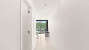 A modern, well-lit hallway with a view of a cityscape through a large window. - D436 - Lovely apartment with balcony & lagoon view (Cole Bay)