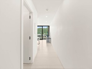 A modern, well-lit hallway with a view of a cityscape through a large window. - D436 - Lovely apartment with balcony & lagoon view (Cole Bay)