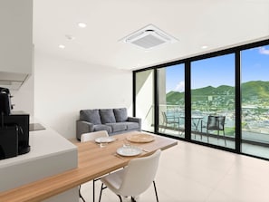 A modern living space with a dining area, a sofa, and a view of a marina. - D436 - Lovely apartment with balcony & lagoon view (Cole Bay)