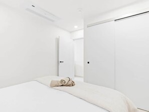 A minimalist bedroom with a bed, a closet, and a door. - A135 - Beautiful one bedroom apartment (Cole Bay)