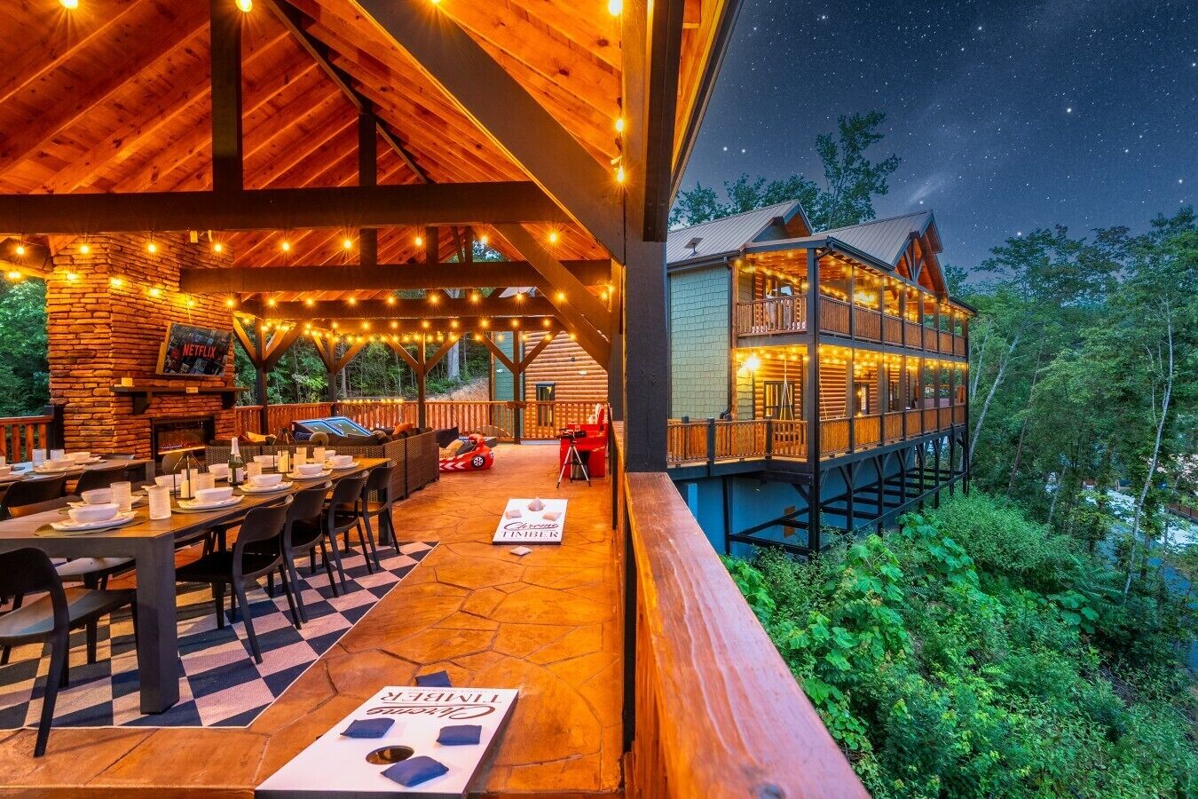 An outdoor dining area with tables and chairs, a stone fireplace, and a sign for 'Netflix.'