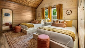 A cozy cabin-style bedroom with two beds, a large mirror, and a wooden ceiling. - Chrome&Timber|Pool|Sauna|HotTub|FirePit|Sleeps 33 (Sevierville)