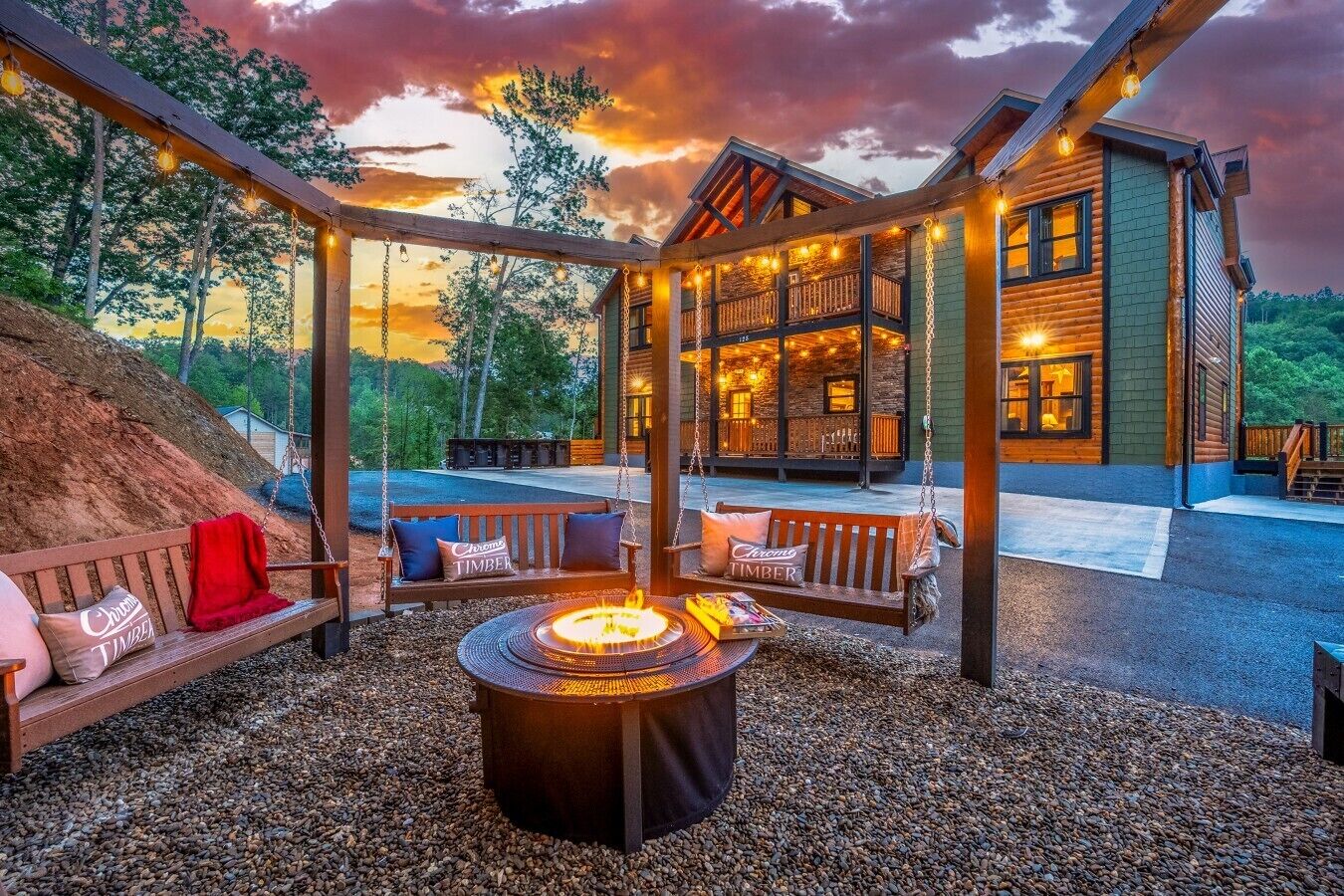 A wooden cabin with a fire pit, outdoor seating, and a view of the surrounding forest.