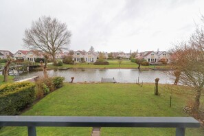 A residential area with houses, a pond, and a bridge. - Comfortable 4-person Bungalow With Jetty (Makkum)