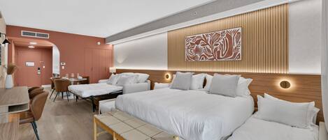 A modern hotel room with a large bed, bedside tables, a desk, and a chair.