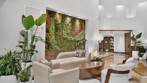 Un vestíbulo moderno con sofá, mesa de centro y plantas en macetas.