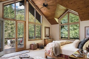 A spacious bedroom with large windows, a wooden ceiling, and a view of the outdoors. - Mountain Home w/ Private Hot Tub & Garage (Jackson Hole)