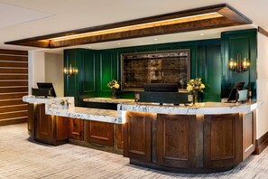 A reception desk with a marble top, wooden paneling, and a large framed artwork above. - Mountain Home w/ Private Hot Tub & Garage (Jackson Hole)