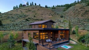 Una casa moderna de dos pisos con un balcón y un jacuzzi.