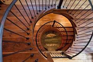 A spiral staircase with wooden steps and metal balusters. - Grand Alpine Lodge w/ Sauna, Hot Tub & Game Room (Jackson Hole)