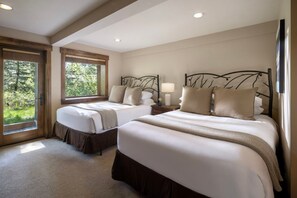 A bedroom with two beds, a large window, and a view of greenery. - Grand Alpine Lodge w/ Sauna, Hot Tub & Game Room (Jackson Hole)