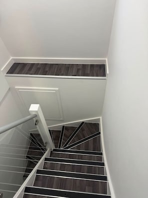 Eine Treppe mit dunklen Holzdielen und weißen Wänden.