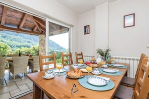 Comedor con una mesa lista para el desayuno, con vistas a un paisaje montañoso.