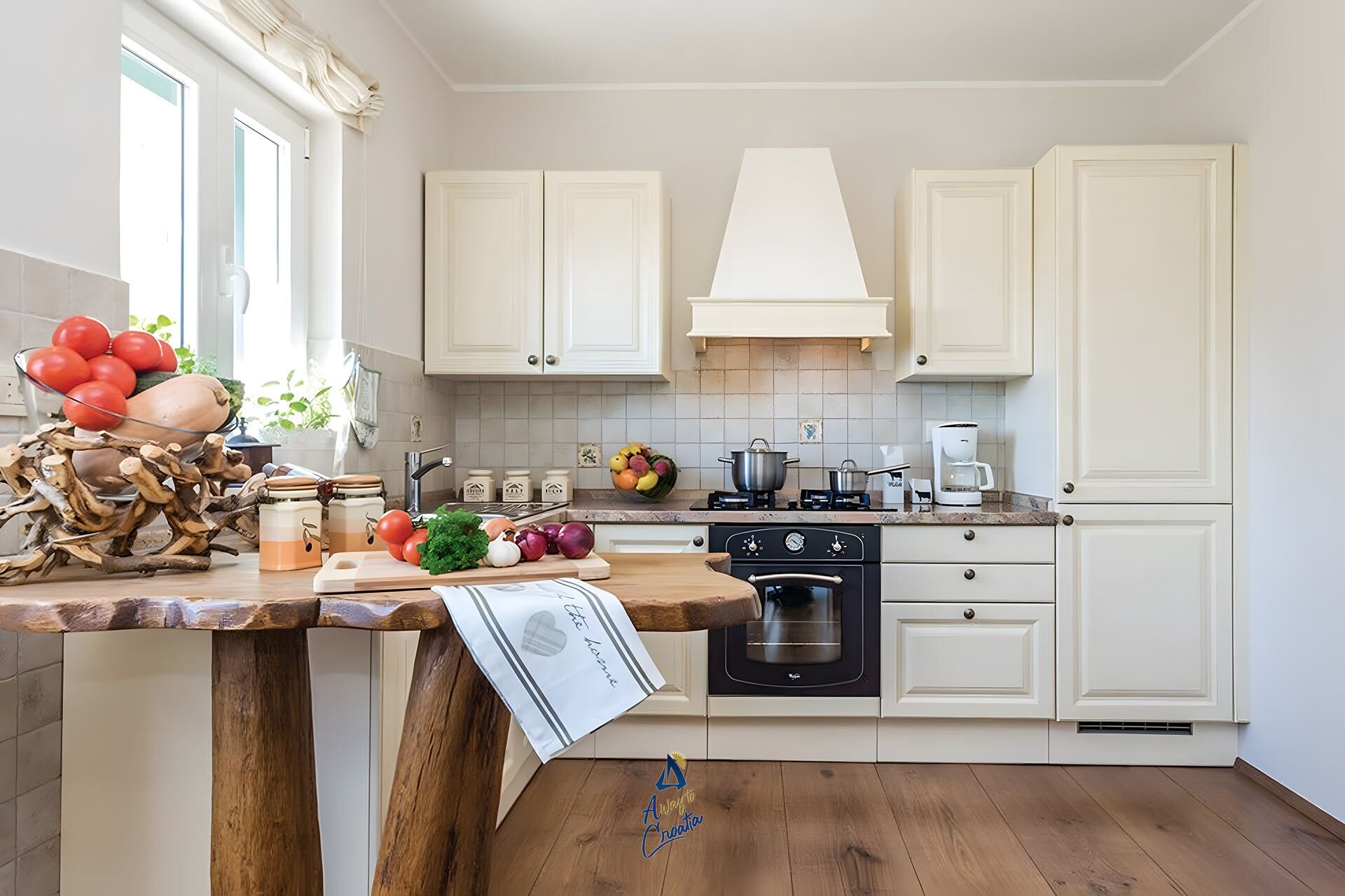 A kitchen with white cabinets, a stove, an oven, and a coffee maker.