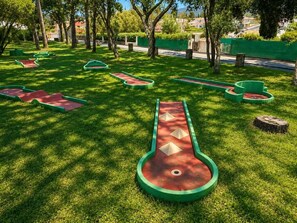 Ein Park mit einem Shuffleboardfeld und grünen Wegen.