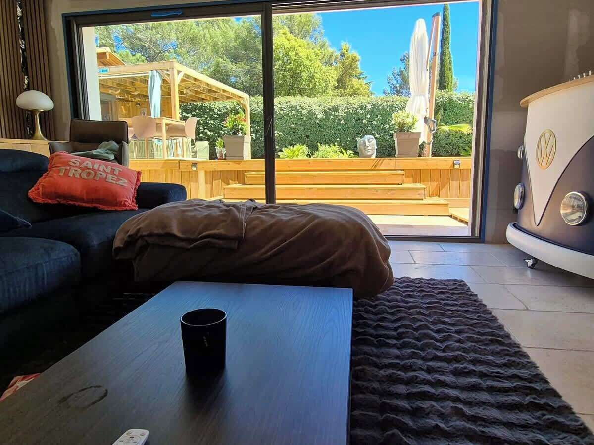 A modern living room with a sofa, a coffee table, and a large window.
