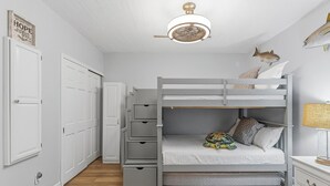 A bunk bed with a built-in desk and drawers, a ceiling fan, and a wall-mounted fish decoration. - Marker 33 #1c3 (New Smyrna Beach)