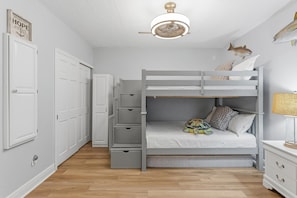 A bunk bed with a built-in desk and drawers, a ceiling fan, and a wall-mounted fish decoration. - Marker 33 #1c3 (New Smyrna Beach)