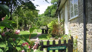 A garden entrance with a wooden gate labeled 'Nuthatch Cottage.' - Coastal Family House for 8 in Cornwall (Axminster)