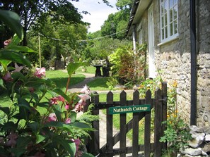A garden entrance with a wooden gate labeled 'Nuthatch Cottage.' - Coastal Family House for 8 in Cornwall (Axminster)