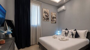A modern bedroom with a bed, a desk, and a window with curtains. - Natia Sicily Villa Anita (Sicilia)