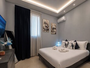 Ein modernes Schlafzimmer mit Bett, Schreibtisch und einem Fenster mit Vorhängen.