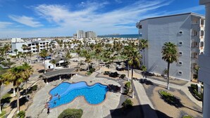 A resort with a swimming pool, palm trees, and a view of the sea. - Pets love sandy beach at casa blanca (Puerto Peñasco)