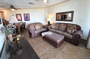 A living room with a sofa set, a coffee table, a lamp, and a mirror on the wall. - Pets love sandy beach at casa blanca (Puerto Peñasco)