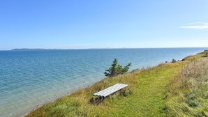 A bench by the water's edge with a clear view of the sea and distant land. - 3 bedroom cozy home in Fur (Fur)