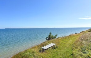 A bench by the water's edge with a clear view of the sea and distant land. - 3 bedroom cozy home in Fur (Fur)