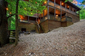 Eine mehrstöckige Holzhütte mit Sitzgelegenheiten im Freien und einer Treppe zu den oberen Ebenen.