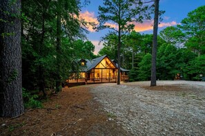 Ein Chalet mit Steinunterbau, Holzfassade und einer Veranda mit Geländern.